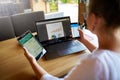 Mixed race woman in glasses working with multiple electronic internet devices. Freelancer businesswoman has tablet and Royalty Free Stock Photo