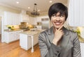 Mixed Race Woman Looking Back Over Shoulder Inside Custom Kitchen Royalty Free Stock Photo