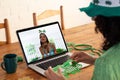 Mixed race woman making st patrick\'s day video call to female friend blowing kiss on laptop at home Royalty Free Stock Photo