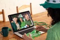 Mixed race woman making st patrick\'s day video call to smiling male friends on laptop at home