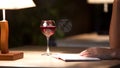 Mixed race woman reading exciting book and drinking red wine in cafe, closeup Royalty Free Stock Photo