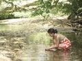 Mixed Race Woman Squatting In Forest Lake