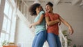 Mixed race young beautiful girls dancing on a bed together having fun leisure in bedroom at home Royalty Free Stock Photo