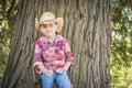 Mixed Race Young Boy Wearing Cowboy Hat Standing Outdoors.