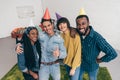 mixed race young man thumb up standing with friends in party