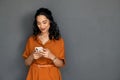 Mixed race young woman using smartphone isolated on grey wall Royalty Free Stock Photo