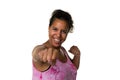 Mixed raced young woman in pink shirt exercising by making punches isolated in white