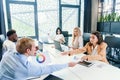 Mixed races coworkers analysing different business papers and working with computers at the tables in modern office. Royalty Free Stock Photo