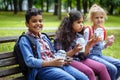 Mixed Racial Group of school kids eating lunch together on break outdoors near school. Back to school concept. Royalty Free Stock Photo