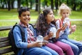 Mixed Racial Group of school kids eating lunch together on break outdoors near school. Back to school concept. Royalty Free Stock Photo