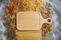 Mixed raw pasta with wooden board on old black desk Royalty Free Stock Photo