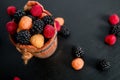 Mixed of red, black, yellow raspberries in a basket on wooden background. Close up. Top view. Copy spase. Royalty Free Stock Photo