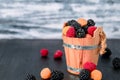 Mixed of red, black, yellow raspberries in a wooden basket and berry on table. Close up. Royalty Free Stock Photo