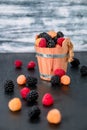 Mixed of red, black, yellow raspberries in a wooden basket and berry on table. Close up. Royalty Free Stock Photo