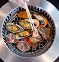 Mixed Roasted Meat and Seafood and Chopsticks on the BBQ Grill o Royalty Free Stock Photo