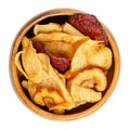 Mixed root vegetable crisps, sliced and fried root veg, in a wooden bowl