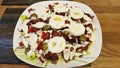 Mixed salad of eggs, olives, onion, dried tomatoes, cherry tomato and bacon.