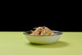 Mixed salad with mixed greens, cucumber, brocolli, sesame seeds and carrots served in a bowl on bright green background