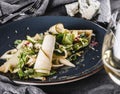 Mixed salad with pear, cheese gorgonzola and sea buckthorn sauce in a ceramic plate over grey background. Healthy vegan food, Royalty Free Stock Photo