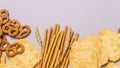 Mixed Salt Crackers Mini Pretzels Bread Sticks and Crackers on Blue Background Long Top View Snack