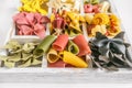 Mixed set of dry multi-colored Italian pasta on a white old wooden box. Background. Close up. Royalty Free Stock Photo