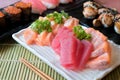 Mixed sliced fish sashimi in white plate. Sashimi Salmon and Tuna set with Tuna, flying fish roe caviar and Foie Gras closeup.