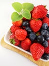 Mixed fruit berries on white plate. Closeup of forest fruits. Summer fruit Royalty Free Stock Photo