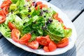 Mixed summer salad on wooden ground