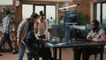 Mixed team of software engineers brainstorming ideas for new code library in front of computer screens