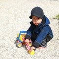 Toddler boy playing on playground - excavator in sand Royalty Free Stock Photo