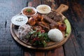 Mixed turkish kebab plate with rice, vegetables and dip sauces on rustic wooden background Royalty Free Stock Photo