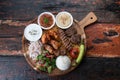 Mixed turkish kebab plate with rice, vegetables and dip sauces on rustic wooden background