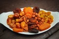 Mixed turkish nuts walnuts, raisins, dried apricots, almonds, hazelnuts. Assorted nuts and dried fruits in white plate.