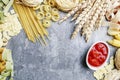 Mixed types and shapes of italian pasta on grey stone, background Royalty Free Stock Photo