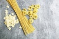 Mixed types and shapes of italian pasta on grey stone, background Royalty Free Stock Photo