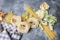 Mixed types and shapes of italian pasta on grey stone background Royalty Free Stock Photo
