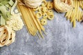 Mixed types and shapes of italian pasta on grey stone background Royalty Free Stock Photo