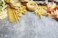 Mixed types and shapes of italian pasta on grey stone background Royalty Free Stock Photo