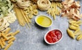 Mixed types and shapes of italian pasta on grey stone background Royalty Free Stock Photo