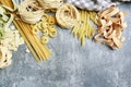 Mixed types and shapes of italian pasta on grey stone background Royalty Free Stock Photo