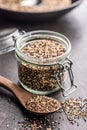 Mixed uncooked quinoa seeds on spoon on black table Royalty Free Stock Photo