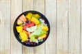 Mixed vegetable and fruit salad in black bowl Royalty Free Stock Photo