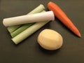 Mixed vegetable leeks, carrot, potatoes on the green wooden background