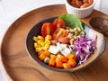 Mixed vegetable salad with tomato, corn, carrot, green peas, red cabbage, cos lettuce, granola, crispy coconut chips on brown bowl Royalty Free Stock Photo