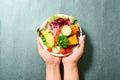 Mixed vegetables salad holding by hand Royalty Free Stock Photo