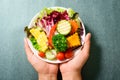 Mixed vegetables salad on white dish holding by hand Royalty Free Stock Photo