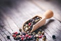 Mixed whole pepper on a wooden scoop. Natural old background. Concept of food, spice Royalty Free Stock Photo