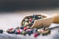 Mixed whole pepper on a wooden scoop. Natural old background. Concept of food, spice Royalty Free Stock Photo