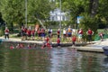 A mixed youth group with their adult supervisors as they dive and swim from a small jetty on the river at Henley on Thames