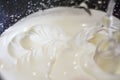 The mixer mixes thick, white cream